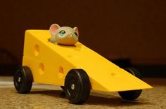 a yellow toy car with a mouse in it