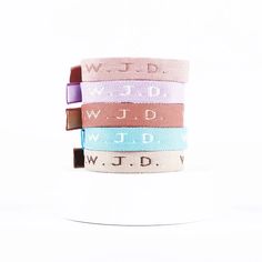 four bracelets with words on them are stacked in the shape of letters and numbers