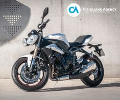 a black and silver motorcycle parked in front of a wall