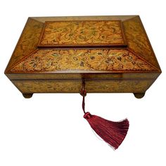 an ornate wooden box with a tassel hanging from it