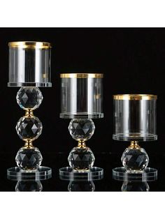 three clear glass candlesticks with gold trim