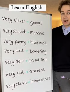 a man standing next to a white board with words written on it