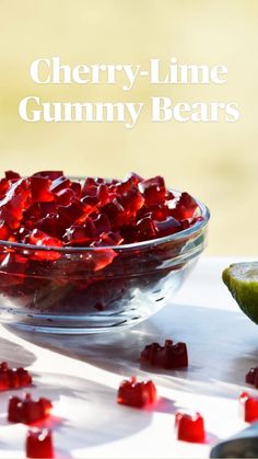 a glass bowl filled with red jelly next to a lime