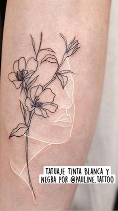 a tattoo on the leg of a woman's thigh with flowers growing out of it