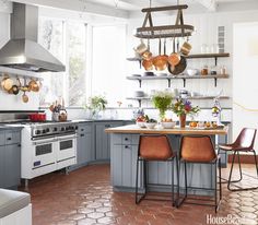 two chairs sit at a kitchen table with pots and pans hanging from the ceiling