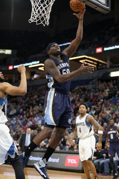 a basketball player is going to dunk the ball in front of two other players