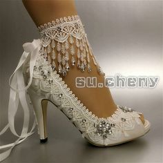 white bridal shoes with lace and pearls on the heel, tied up to a high heel