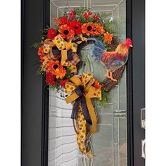 a wreath with roosters and flowers on the front door