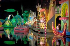 an amusement park is lit up at night with people on boats and inflatable floats