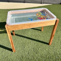 a wooden table with a plastic tray on it and some beads in the bottom drawer