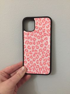 a hand holding an iphone case with pink leopard print