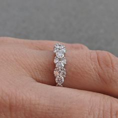 a woman's hand with a diamond ring on her left side, and three diamonds in the middle