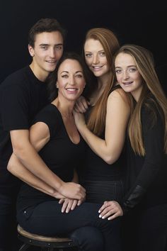 three women and one man are posing for a photo with their arms around each other