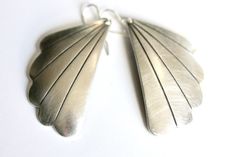 "Just a sweet set of silver angel's wing earrings with an Art Deco vibe. Pendants are about 1 1/2\" long x 1\" across at the widest point. Ear wires are sterling silver, and pendants are lightweight for sensitive ears. EARRING BACKS Ear wires are lead-free and nickel-free .925 sterling silver French loop or lever back. Earrings from my shop have the choice of high quality, hinged lever back or simple French loop ear wires. Lever backs are great if you're always losing your earrings, but all earrings with simple French loops from my shop arrive with clear rubber clutches to prevent them from loss, too. French loops have a 1/4\" drop; lever backs have a 1/2\" drop. Use the drop down menu to select your preference. STAY IN TOUCH! I send emails every other week: https://minusonejewelry.com/con Elegant Winged Metal Jewelry, Handmade Silver Wing-shaped Earrings, Elegant Angel Wings Earrings, Elegant Metal Wing-shaped Earrings, Art Deco Sterling Silver Dangle Earrings, Handmade Sterling Silver Art Deco Earrings, Elegant Wing-shaped Metal Earrings, Nickel-free Art Deco Sterling Silver Jewelry, Elegant Winged Earrings For Gift