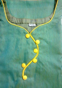 a green shirt with yellow buttons on the front and side, attached to a string