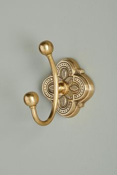 an ornately designed brass hook on the wall