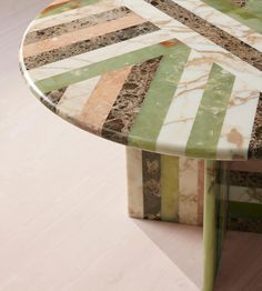 a round marble table with multicolored stripes on it's top and bottom