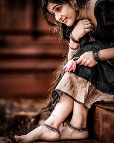 a woman sitting on top of a wooden bench