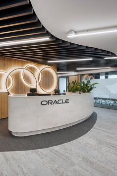 an office reception area with circular lights and wood paneling on the wall, along with a plant