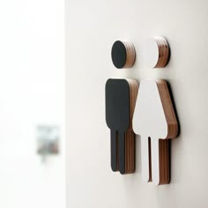 two wooden figures are attached to the wall, one is white and the other is black