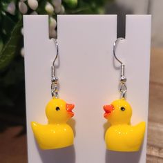 a pair of yellow rubber ducks hanging from earrings