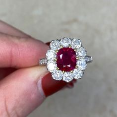 This ring features a cushion cut natural non-heated Burma ruby, weighing 1.46 carats and set in 18k yellow gold prongs. The center stone is certified by AGL. A halo of old mine cut diamonds surrounds the center stone. Old European cut diamonds are set along the shoulders, which are decorated with fine milgrain. The total diamond weight of this ring is 1.70 carats. This ring is carefully handcrafted with a platinum mounting.
The center stone is a 1.46 carat non-heated Burma ruby, certified by AGL Luxury Cushion Cut Ruby Ring With Diamond, Luxury Cushion Cut Ruby Ring With Halo Setting, Classic Gia Certified Cushion Cut Ruby Ring, Luxury Gia Certified Cushion Cut Ruby Ring, Classic Gia Certified Cushion-cut Ruby Ring, Gia Certified Cushion Cut Ruby Ring For Formal Occasions, Formal Gia Certified Cushion Cut Ruby Ring, Fine Jewelry Ruby Ring With Cushion Brilliant Cut, Cushion Cut Ruby Ring With Diamond