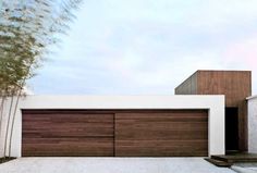 a modern house with wooden garage doors and white walls