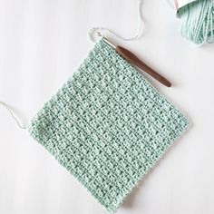 a crochet square with yarn next to it