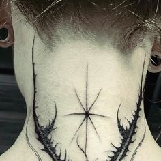 the back of a man's neck with an intricate tattoo design on his neck