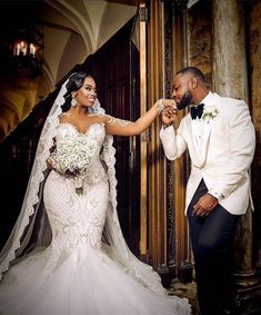 a bride and groom standing in front of a doorway