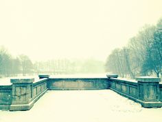 an empty park with benches covered in snow