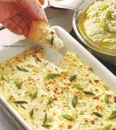 a person dipping something into a casserole dish