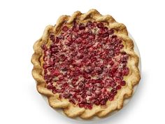 a pie with cranberry toppings on it sitting on top of a white plate