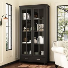 a living room with a white chair and black bookcase