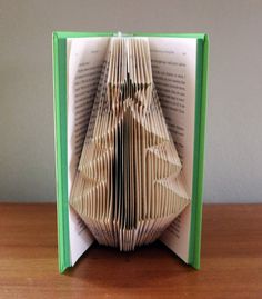 an origami christmas tree is folded into a book