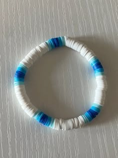 a blue and white beaded bracelet sitting on top of a table