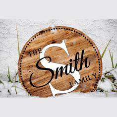 a wooden sign that says, the smith family on it in snow with grass around it