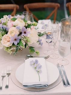 the table is set with flowers and silverware