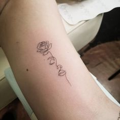 a woman's arm with a rose tattoo on the left side of her arm