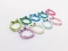 six different colored bracelets on a white surface