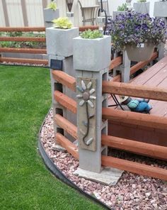 an outdoor garden with flowers and plants on the side of a wooden deck in front of a house