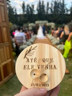 a person holding up a wooden plaque that says ate que elevenha