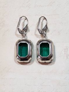 I love the clean simple lines and the sheer emerald green color of these Art Deco style estate earrings. They feature emerald green octagon rhinestone beads and silver plated leverback ear wires. These elegant earrings measure 1 1/4 inches long. Perfect for everyday or evening. ABOUT THIS COLLECTION What are the three style essentials Jazz Age flappers like Clara Bow, Louise Brooks, and Zelda Fitzgerald have in common? Red lipstick, bobbed haircuts, and fabulous dangle earrings. My Flapper Colle Classic Green Clip-on Earrings, Classic Green Drop Earrings, Classic Green Earrings For May Birthstone, Antique Green Jewelry For Evening, Classic Green Clip-on Earrings For Formal Occasions, Classic Green Earrings With Ear Wire, Vintage Green Evening Jewelry, Retro Green Drop Earrings, Victorian Green Earrings For Wedding