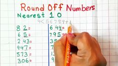 a person holding a pencil in front of a white board with numbers written on it