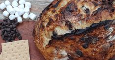 bread, marshmallows and graham crackers on a cutting board next to it