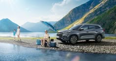 two people fishing off the shore of a lake with a car parked next to it