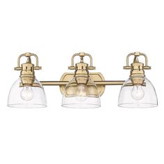 three light bathroom fixture with clear glass shades on the bottom and gold finish, in an antique