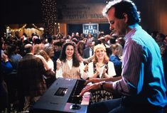 a man playing an electronic keyboard in front of a crowd