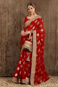 Red saree with all-over woven paisley motifs and dori, badla, kasab embroidery on the border. Comes with half sleeves blouse.
Component: 2
Pattern: Embroidery and Woven
Type Of Work: Dori, Badla and Kasab Work
Neckline: Scoop
Sleeve Type: Half
Fabric: Georgette Butta and Silk Chanderi; Lining: Taffeta Silk
Color: Red
Other Details: 
Embroidered border
Sleeves with bead drops
Low back with tie up and tassels
Note: Polti bag carried by the model is not for sale
Occasion: Wedding - Aza Fashions Polti Bag, Engagement Dress For Bride, Paisley Motifs, Indian Bridal Photos, Indian Wedding Inspiration, Blouse Casual Fashion, Saree Designs Party Wear, Embroidered Saree, Ethnic Outfits