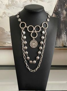 This exquisite long necklace is a nod to vintage sophistication, crafted with care to incorporate elements of timeless elegance and contemporary style. It features a string of lustrous coin-shaped freshwater pearls with a unique porcelain glass finish that provides a soft, reflective sheen. Each pearl is a replica, capturing the classic beauty and charm of vintage jewelry. Interspersed with these pearls is a durable Zamak chain, known for its resistance to oxidation and tarnishing, which adds a Silver Metal Medallion Necklace With Chain, Silver Metal Pearl Necklace With Beaded Chain, Bohemian Metal Necklace With Pearl Chain, Bohemian Style Metal Necklace With Pearl Chain, Elegant Silver Coin Necklace With Chain, Elegant Metal Medallion Necklace, Silver Medallion Jewelry With Pearl Chain, Silver Multi-strand Pearl Chain Necklace, Silver Pearl Beaded Long Necklace